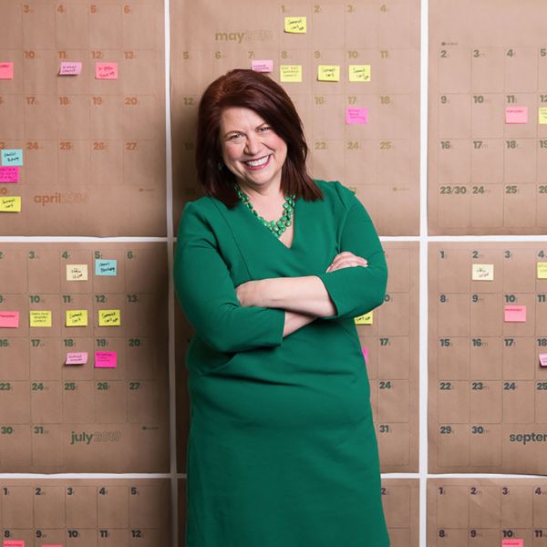 Amelia Franck Meyer standing in front of wall of colorful post-it notes