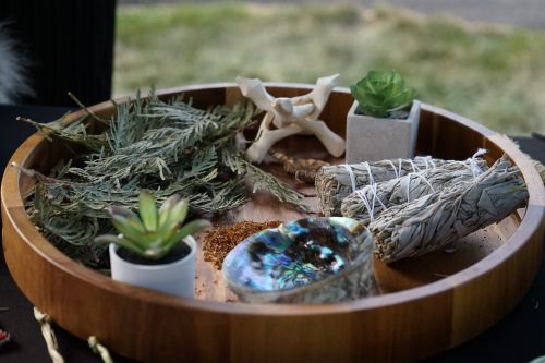 sage, succulents, and brush in a wooden bowl